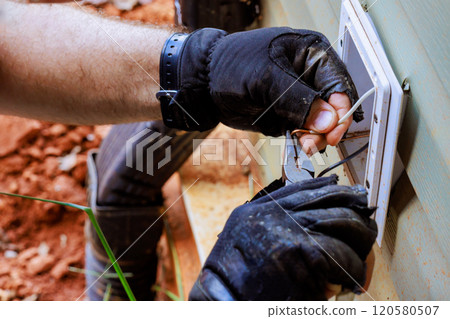 Installation of electrical wires to new outlets requires precision meticulous work 120580507