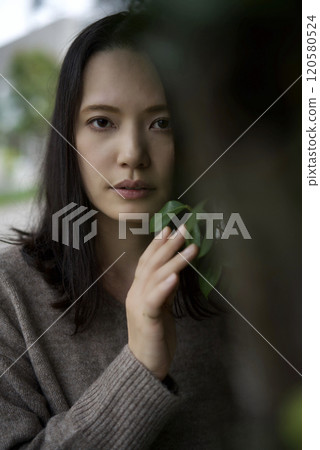 Woman standing next to a tree 120580524