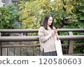 A woman looking at a smartphone outdoors 120580603