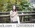 A woman looking at a smartphone outdoors 120580604