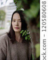 Woman standing next to a tree 120580608