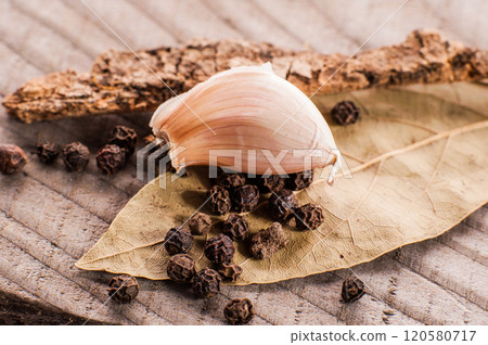 black pepper.Dry spices black pepper on a wooden spoon and dried bay leaf. Spices and seasonings, cooking black pepper.Dry spices black pepper on a wooden spoon and dried bay leaf. Spices and seasonings, cooking 120580717
