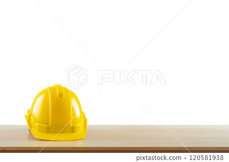 Yellow safety construction helmet on wood table isolated on white background Yellow safety construction helmet on wood table isolated on white background 120581938