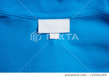 Blank white laundry care clothes label on blue shirt fabric texture background Blank white laundry care clothes label on blue shirt fabric texture background 120582269