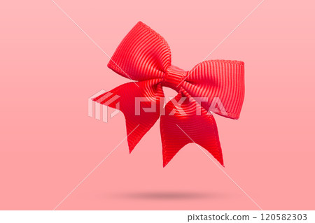 red gift bow isolated on pink background 120582303