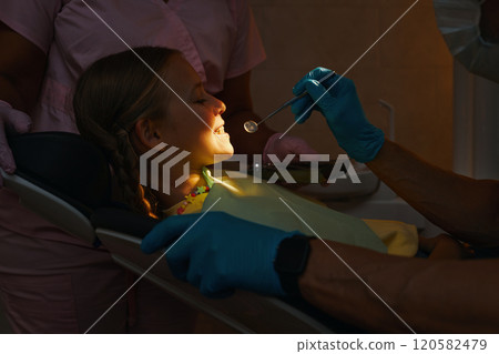 Dentist Checking Young Patient's Teeth During Exam 120582479