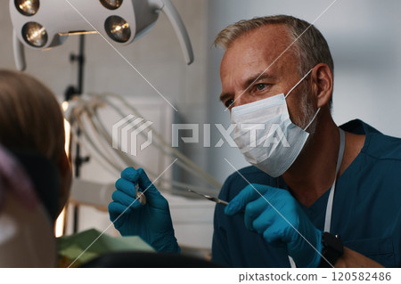 Dentist Treating Patient in Modern Medical Clinic 120582486