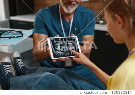 Reviewing Dental X-Rays on Digital Device in Clinic 120582514