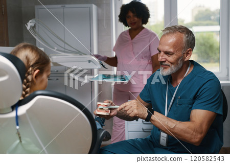 Pediatric Dentist Caring for Young Patient During Checkup 120582543