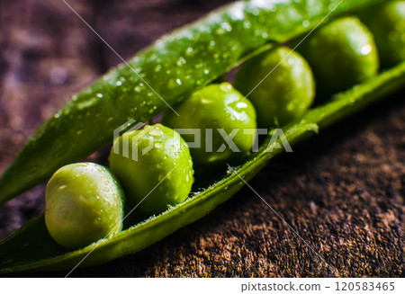 Greem pea on a wooden surface. Macro image.Fresh green peas in a ceramic bowl, pods, on an old wooden surface, top view, still life 120583465