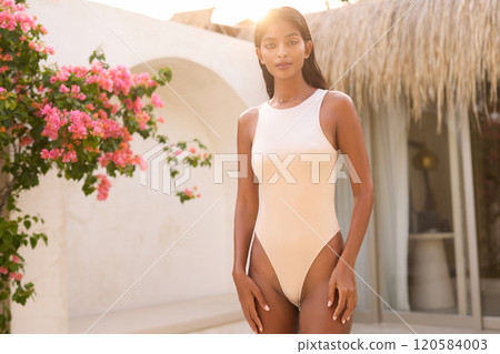 Elegant Woman in Swimsuit Posing by Sunlit Tropical Villa Elegant Woman in Swimsuit Posing by Sunlit Tropical Villa 120584003