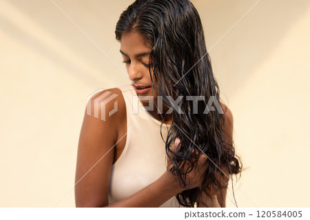 Woman With Wet Hair in Soft Lighting Touching Her Hair Woman With Wet Hair in Soft Lighting Touching Her Hair 120584005