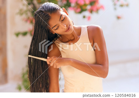 Woman Haircare: Female Combing Hair Outdoors With Natural Light Woman Haircare: Female Combing Hair Outdoors With Natural Light 120584016