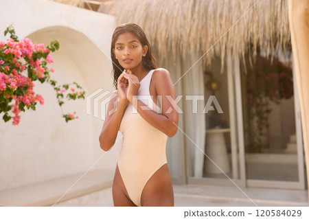 Beautiful Woman in Stylish Swimsuit by Tropical Resort 120584029