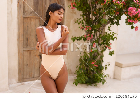 Summer Fashion Model in Stylish Swimsuit Near Floral Garden Summer Fashion Model in Stylish Swimsuit Near Floral Garden 120584159