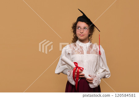 Young graduate in cap and gown holding diploma scroll Young graduate in cap and gown holding diploma scroll 120584581
