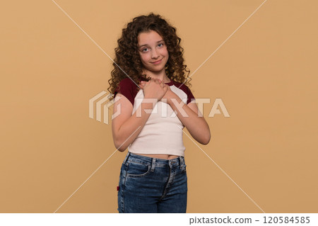 Young girl holding hands to chest, expressing gratitude Young girl holding hands to chest, expressing gratitude 120584585