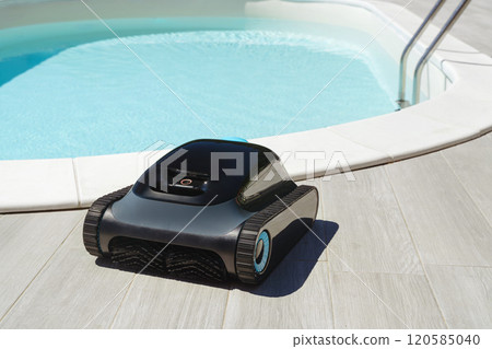 robotic pool cleaner in front of swimming pool with clear blue water 120585040