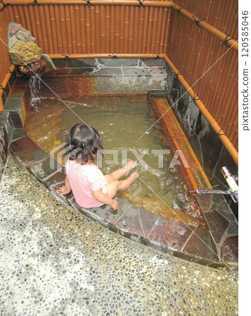 A small child playing in a foot bath in an open-air family bath A small child playing in a foot bath in an open-air family bath 120585046