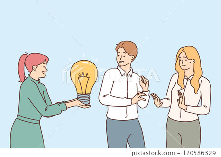 Office employees are critical of idea of female colleague holding light bulb in hands 120586329