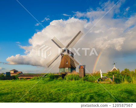 Landscape with windmill and rainbow. Dutch. A huge cloud after a storm. 120587567