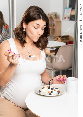 Pregnant woman surprised and skeptical about a healthy breakfast of cottage cheese Pregnant woman surprised and skeptical about a healthy breakfast of cottage cheese 120587687