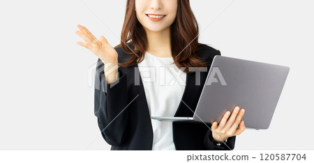 A smiling woman/businesswoman giving directions while holding a computer A smiling woman/businesswoman giving directions while holding a computer 120587704