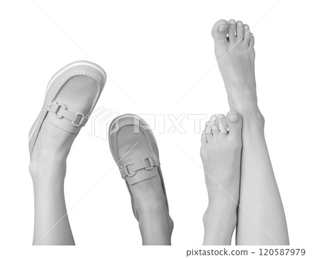 Shoeless feet beside stylish leather loafers with chic chain decor. Modern slip on design with neat 120587979