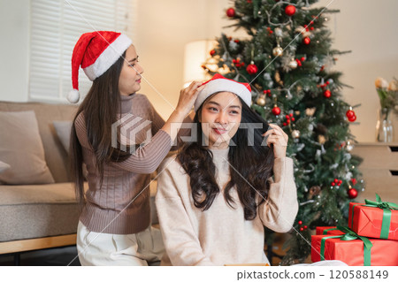 Joyful Young Couple Celebrating Christmas Together with Gifts and Decorations in a Cozy Home Setting Joyful Young Couple Celebrating Christmas Together with Gifts and Decorations in a Cozy Home Setting 120588149