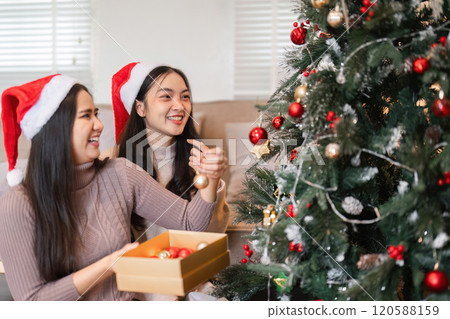 Joyful Young Women Celebrating Christmas Together with Festive Decorations and Cheerful Holiday Spirit 120588159