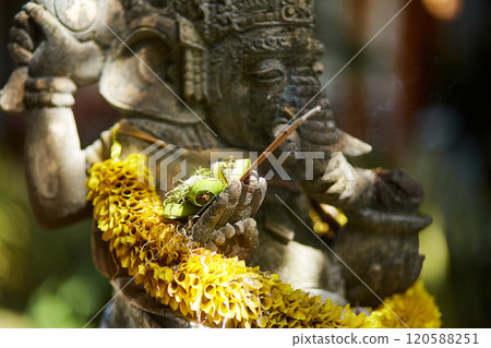 Sculpture of a temple with flowers and incense for ritual offerings on the popular tourist island of Bali. Sculpture of a temple with flowers and incense for ritual offerings on the popular tourist island of Bali. 120588251