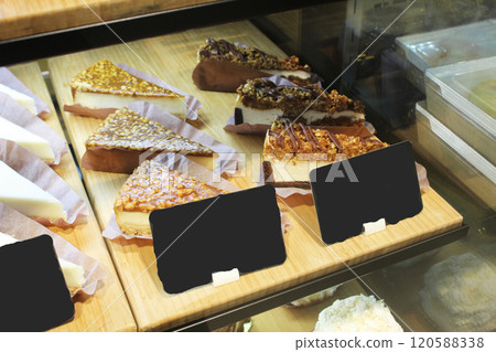 Pieces of cheesecake cakes in the window of a cafe store. Sale of sweets 120588338