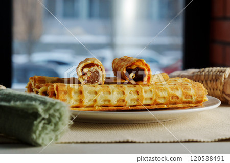 Delight in the sight of freshly made, golden waffles arranged neatly on a round plate Delight in the sight of freshly made, golden waffles arranged neatly on a round plate 120588491