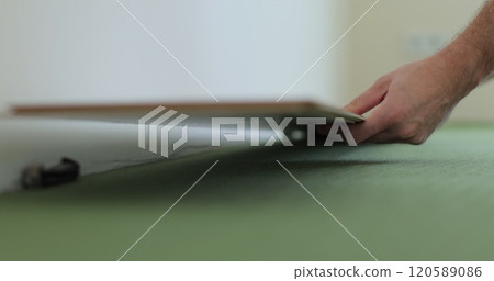 Man lays laminate flooring on the floor in a room. Repair of the floor of the house. 120589086