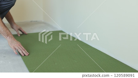 Laying underlay for the laminate flooring. Preparatory work before laying a laminate board. Laying a polypropylene substrate under the laminate. Renovation of a new house. 120589091