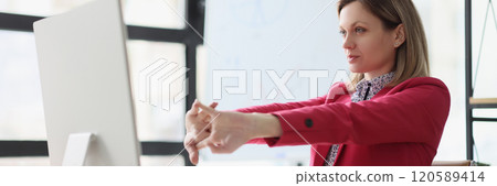 Lady manager stretches arms before starting work on computer 120589414
