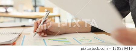 Secretary examines reports with diagrams and statistics 120589419