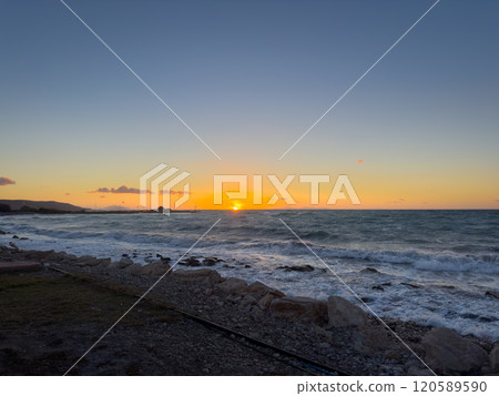 Sunset Over the Ocean With Waves Crashing on Rocky Shore During Twilight Hours at Coastal Location Sunset Over the Ocean With Waves Crashing on Rocky Shore During Twilight Hours at Coastal Location 120589590