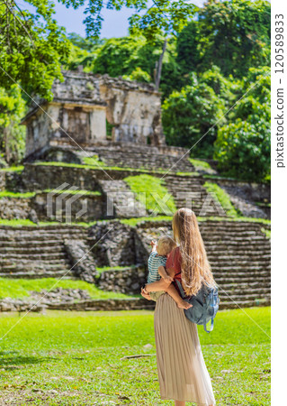 Mother and son tourists exploring the ancient pyramids of Palenque, Mexico, surrounded by dense jungle. Cultural heritage and adventure travel concept 120589833