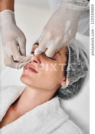 Professional skincare treatment being applied to a woman in a spa setting Professional skincare treatment being applied to a woman in a spa setting 120589869