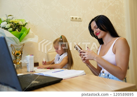 Mother and daughter enjoying creative time together in a cozy room 120589895