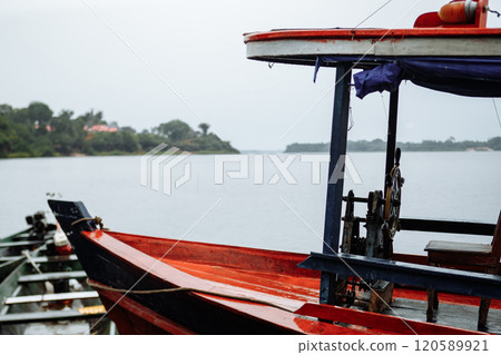 Fishing boats moored by the tranquil waters of a river on a cloudy day 120589921