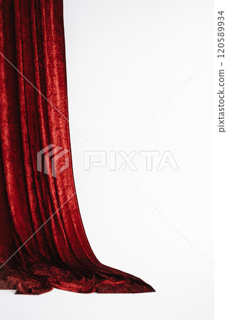 A red curtain hangs in front of a white background with copy space 120589934
