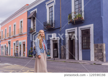 Female tourist walking through the colorful colonial streets of Puebla, Mexico. Travel, cultural exploration, and vibrant architecture concept 120590198