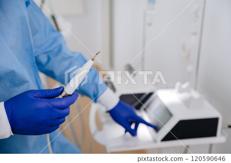 Dental professional preparing ultrasonic scaler for teeth cleaning in a modern dental clinic 120590646