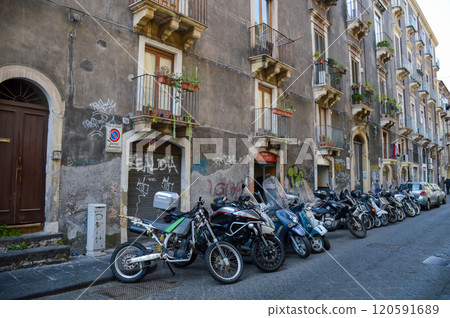 Motorcycles are parked in front of a building with falda sign 120591689