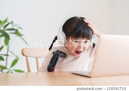 Child playing video games on laptop 120591710