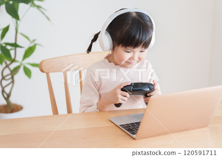 Child playing video games on laptop Child playing video games on laptop 120591711