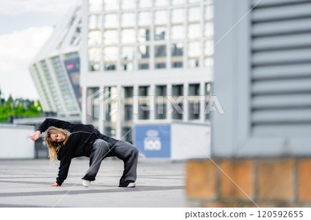 Dancer performs dynamic moves in urban environment on a cloudy day Dancer performs dynamic moves in urban environment on a cloudy day 120592655