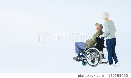Full-body photo of a senior couple walking while pushing a wheelchair 120593460
